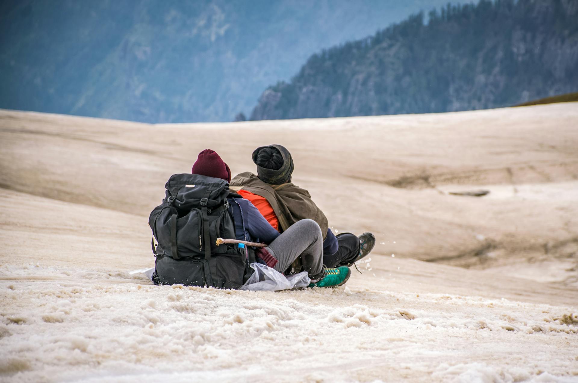 Two People Riding in Sled on Snow