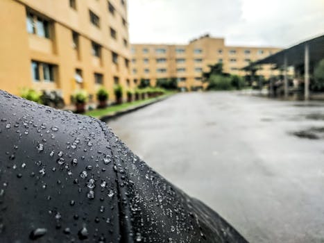 以城市建筑为背景，特写雨滴表面的画面捕捉到了雨天的气氛
