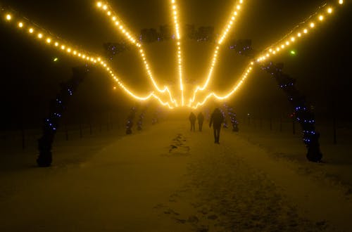 People Walking on a Snow Covered Ground at Night