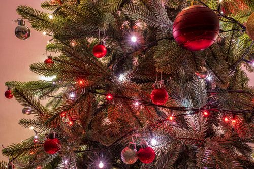 Free Close-up of a decorated Christmas tree with glowing lights and ornaments. Stock Photo