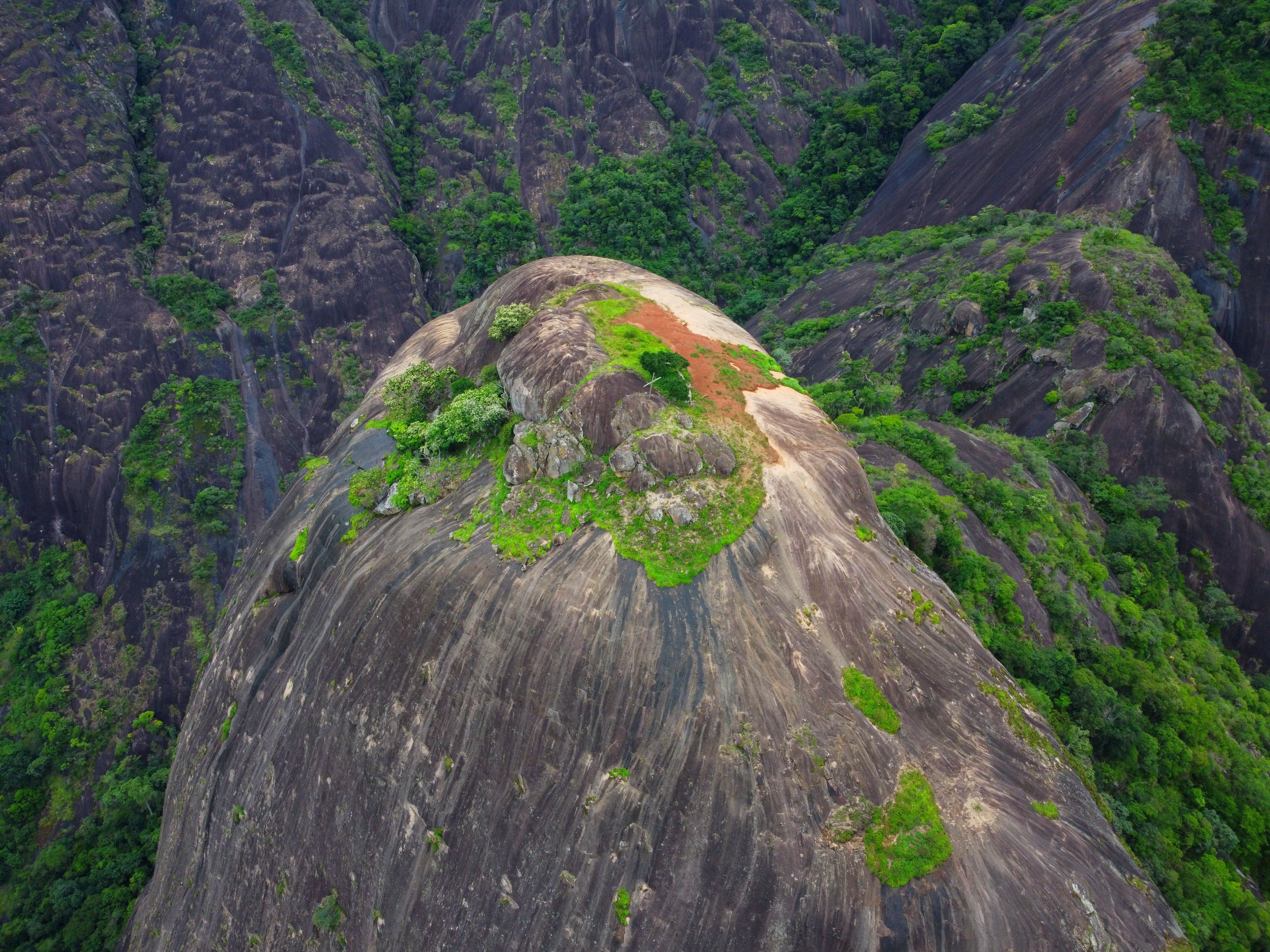 Breathtaking aerial view of a lush, green mountain peak in Afonso Cláudio, Brazil, showcasing natural beauty.