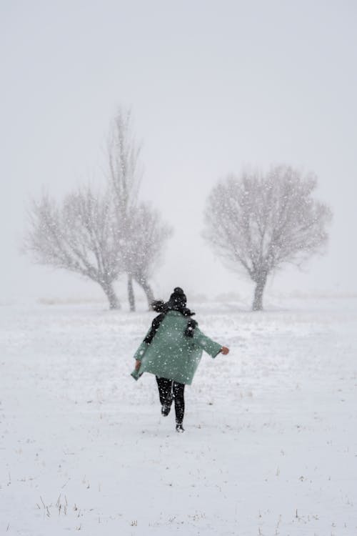 A Person Running on Snow Covered Ground Under the Snow