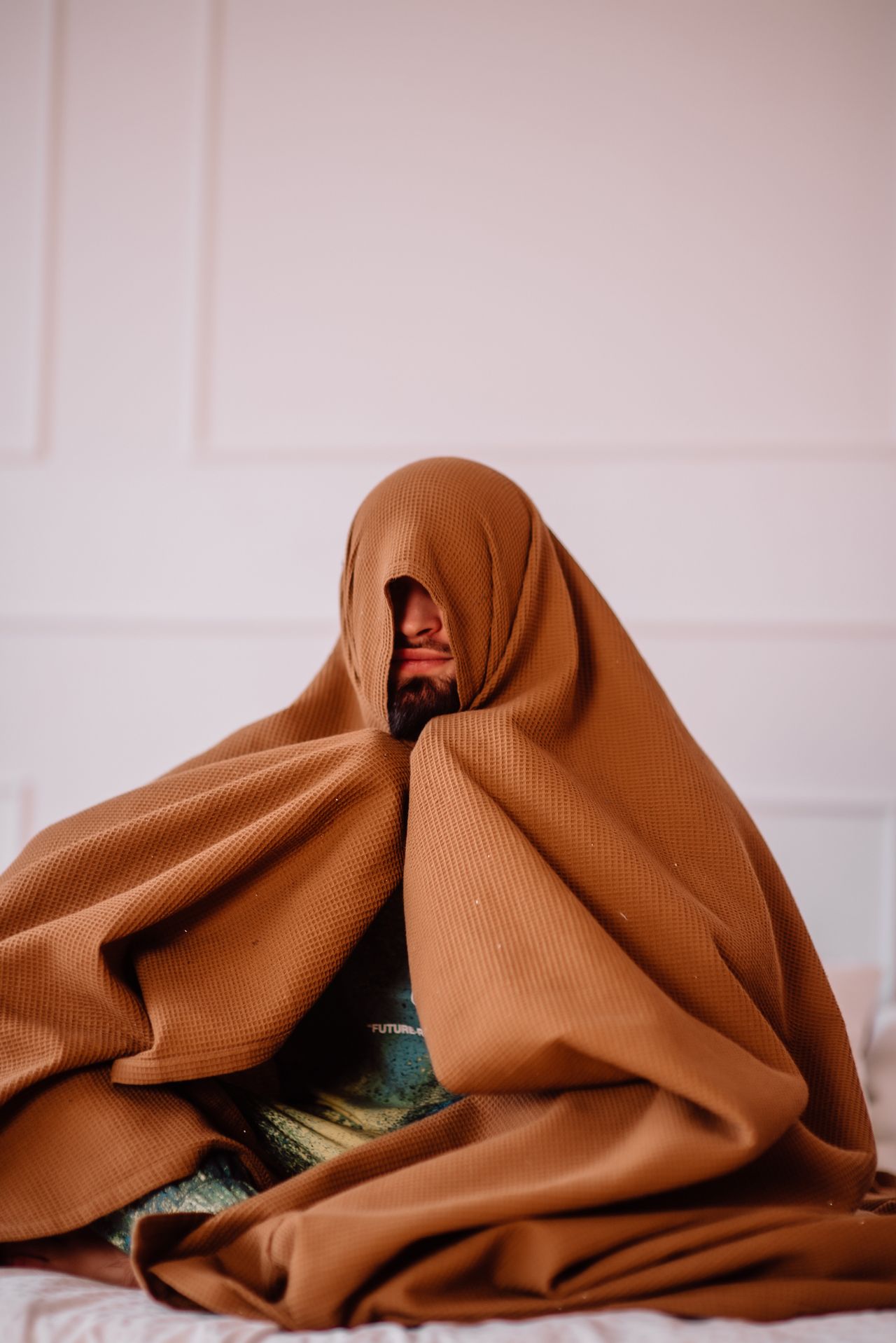 Person wrapped in a cozy brown blanket