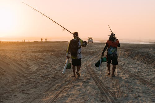 Backview of Men carrying Fishing Rods 