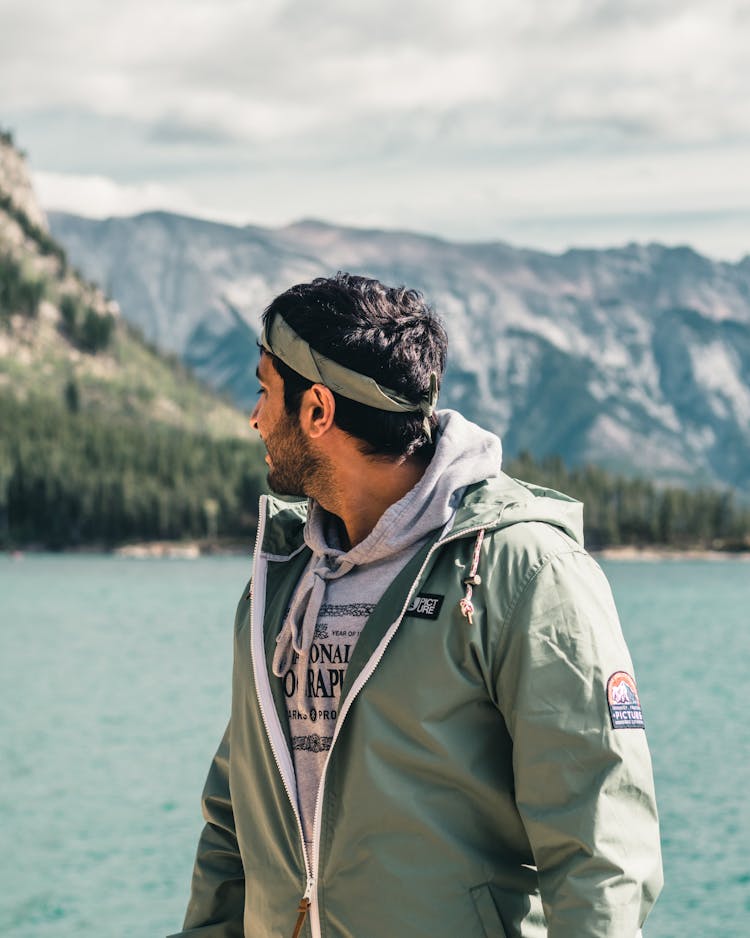 A Man Wearing A Jacket While Looking Over Shoulder