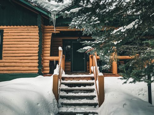 Free A cozy log cabin with a snowy entrance in Mont-Tremblant, Quebec. Stock Photo