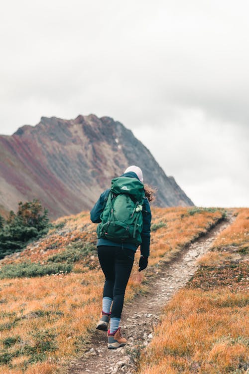 A Person Trekking while Carrying It's Backpack