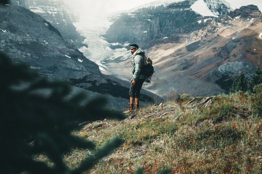 A hiker with a backpack explores the stunning glacial landscape in Jasper National Park, Alberta, Canada.