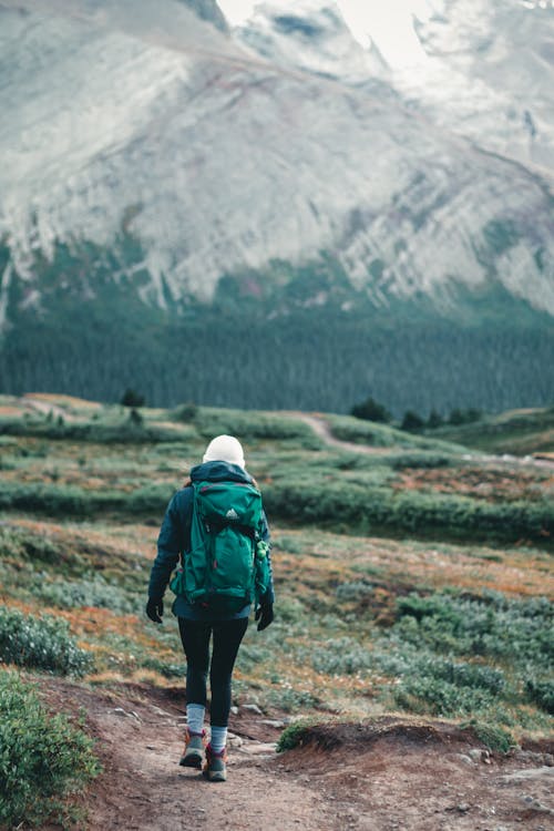 A Person Walking on the Field while Carrying a Backpack