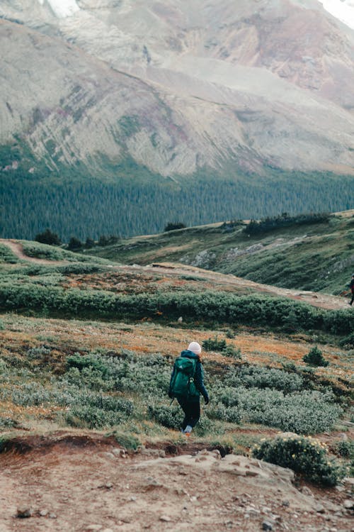 A Person Carrying a Backpack while Walking on the Field