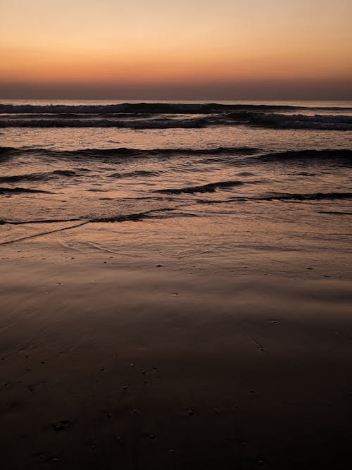 akşam karanlığı, çarpmak, dalgalar içeren Ücretsiz stok fotoğraf