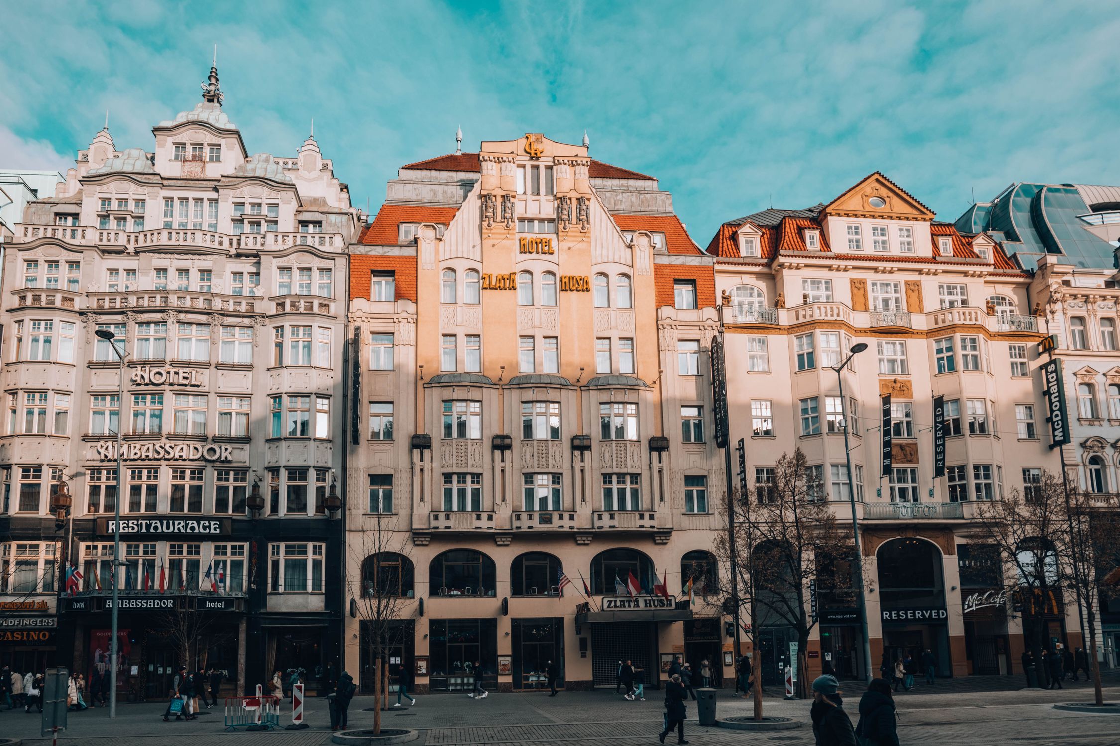 Front view of historical buildings in Wenceslas Square, Prague, showcasing Hotel Zlata Husa.