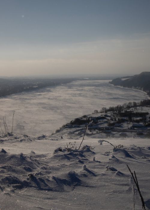 Free A serene aerial view of a snow-covered river landscape in winter. Stock Photo
