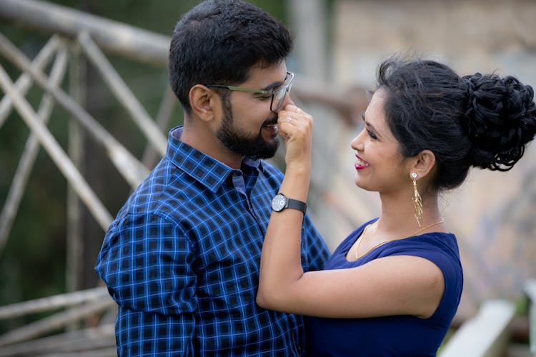 A Woman Pinching A Man's Nose