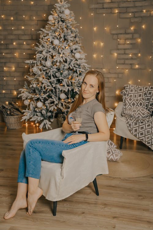 Woman in Armchair in front of Christmas Tree
