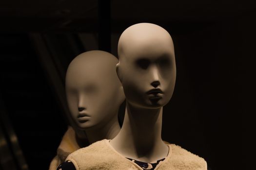 Close-up of two mannequins in dim lighting, creating a mysterious and eerie ambiance.