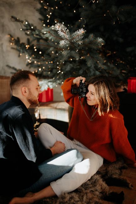 A couple enjoying a cozy, affectionate moment by the Christmas tree, capturing memories.