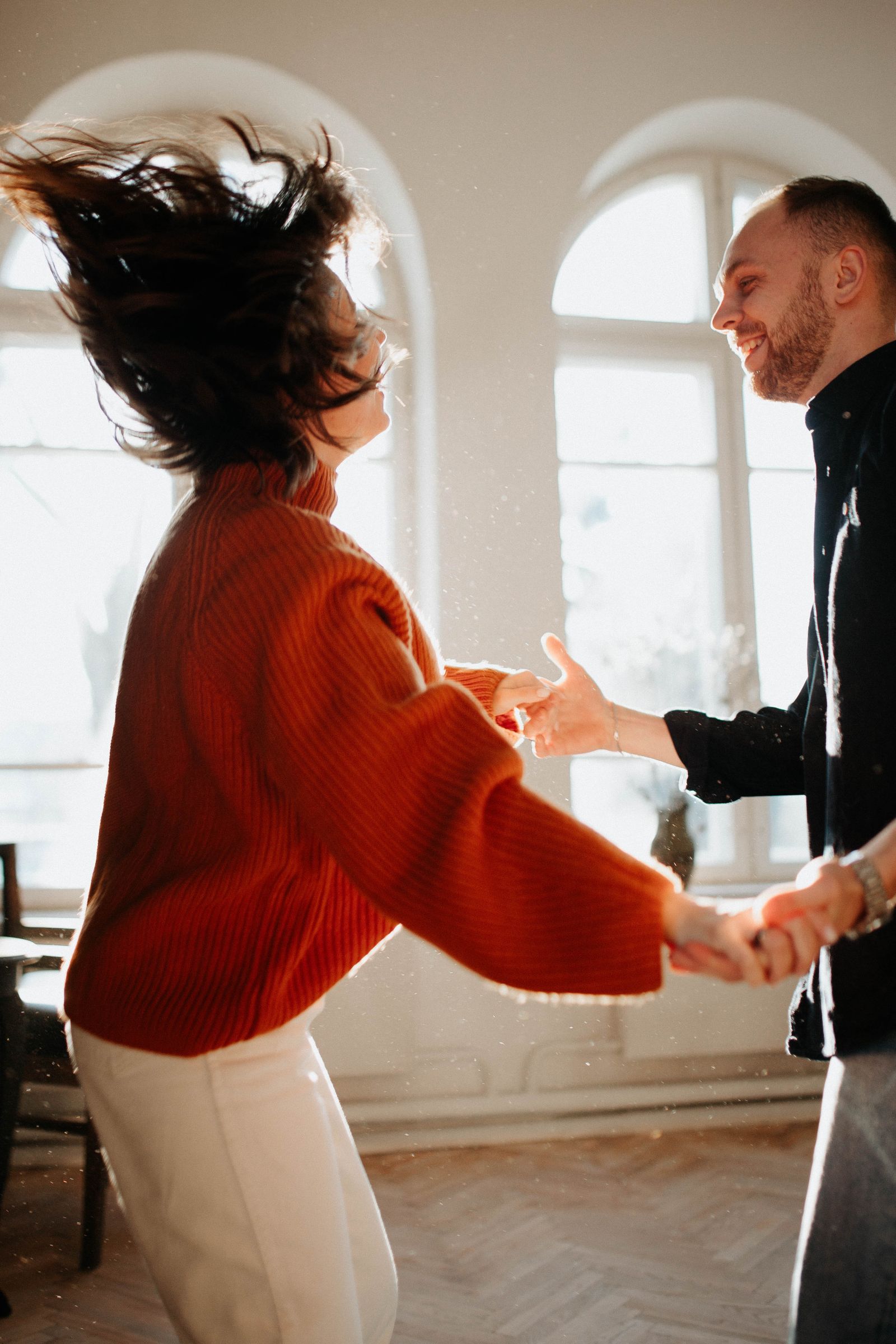 Joyful couple dancing in a bright sunlit room — stock photo