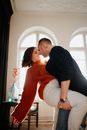 Man in Red Sweater Sitting Beside Woman in Black Sweater