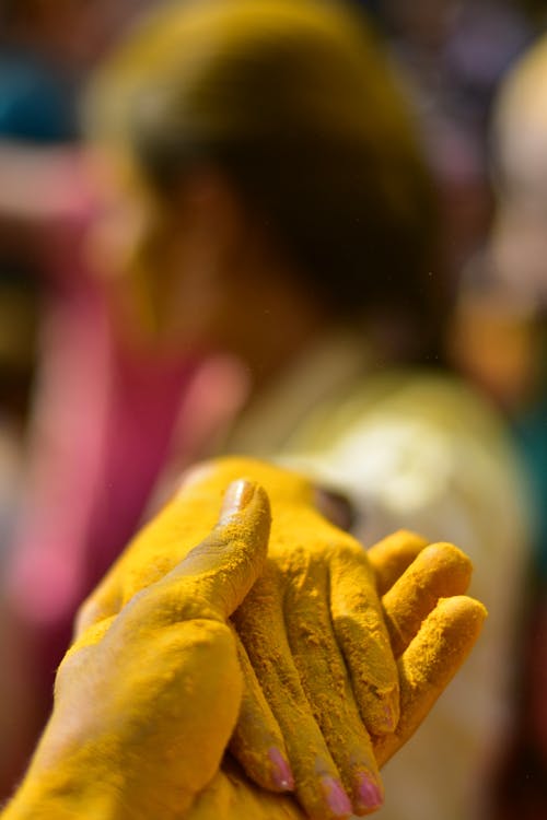 Persons Hand on Yellow Textile