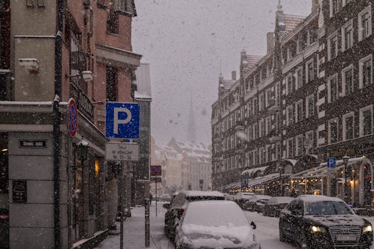 A snowy street scene in Riga's Old Town, capturing the historic architecture amidst falling snow.