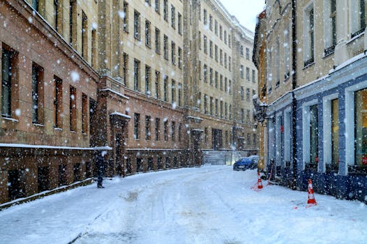 A serene snowy street in Riga, Latvia, showcasing historic architecture amidst falling snowflakes.
