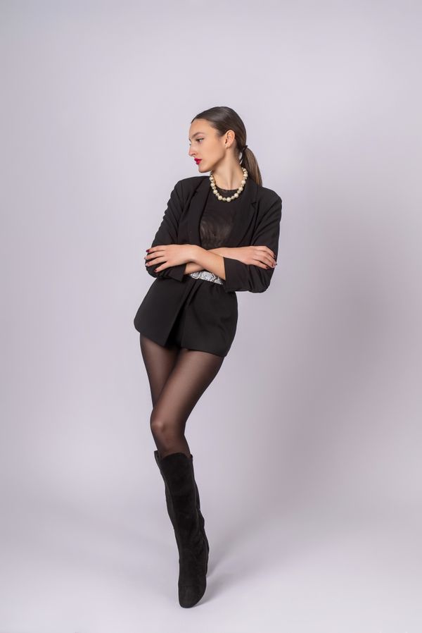 woman in tailored black shorts with sheer tights and heeled ankle boots