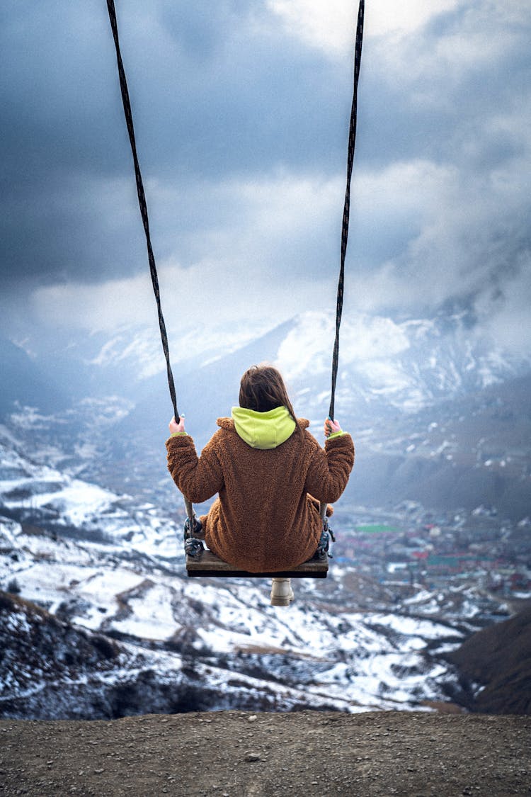 Woman On Swing At The Edge Of Cliff