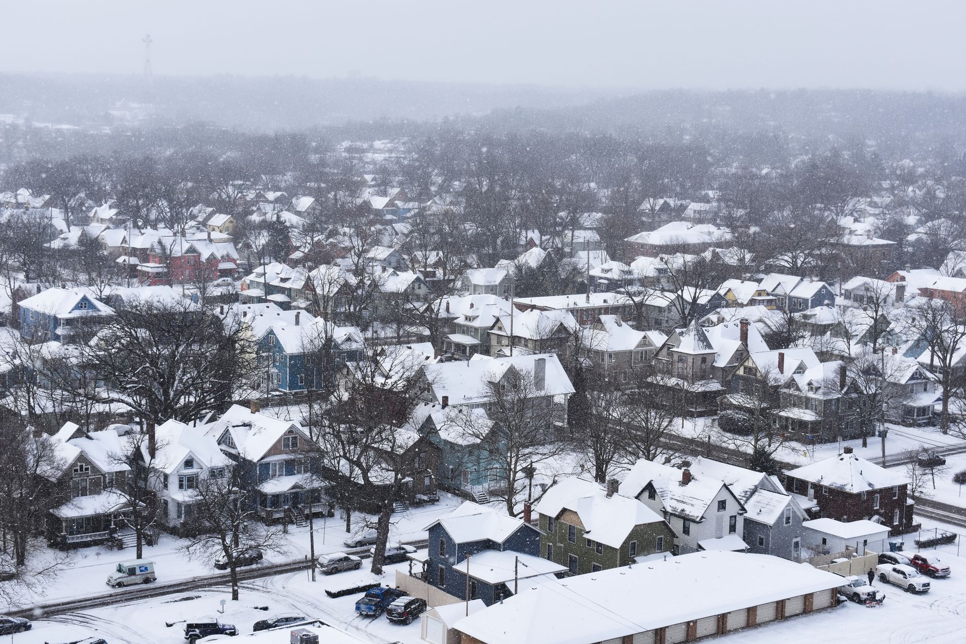 Aerial view of a snow-covered town with houses blanketed in winter snow.