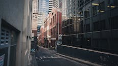 探索一条城市小巷，其特色在于现代建筑和玻璃窗的倒影