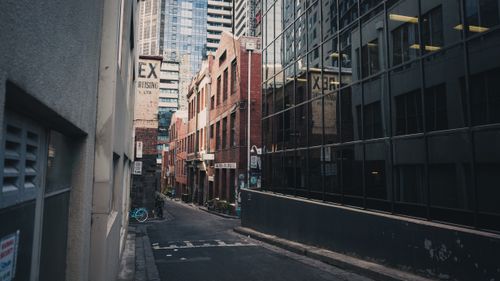 Free Explore an urban alleyway featuring modern architecture and reflections on glass windows. Stock Photo
