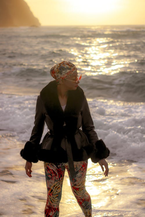 A Woman in Black Coat Standing on Beach