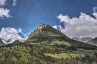 美丽的山脉下，郁郁葱葱的松树林映衬着湛蓝的天空，是自然和冒险爱好者的完美去处