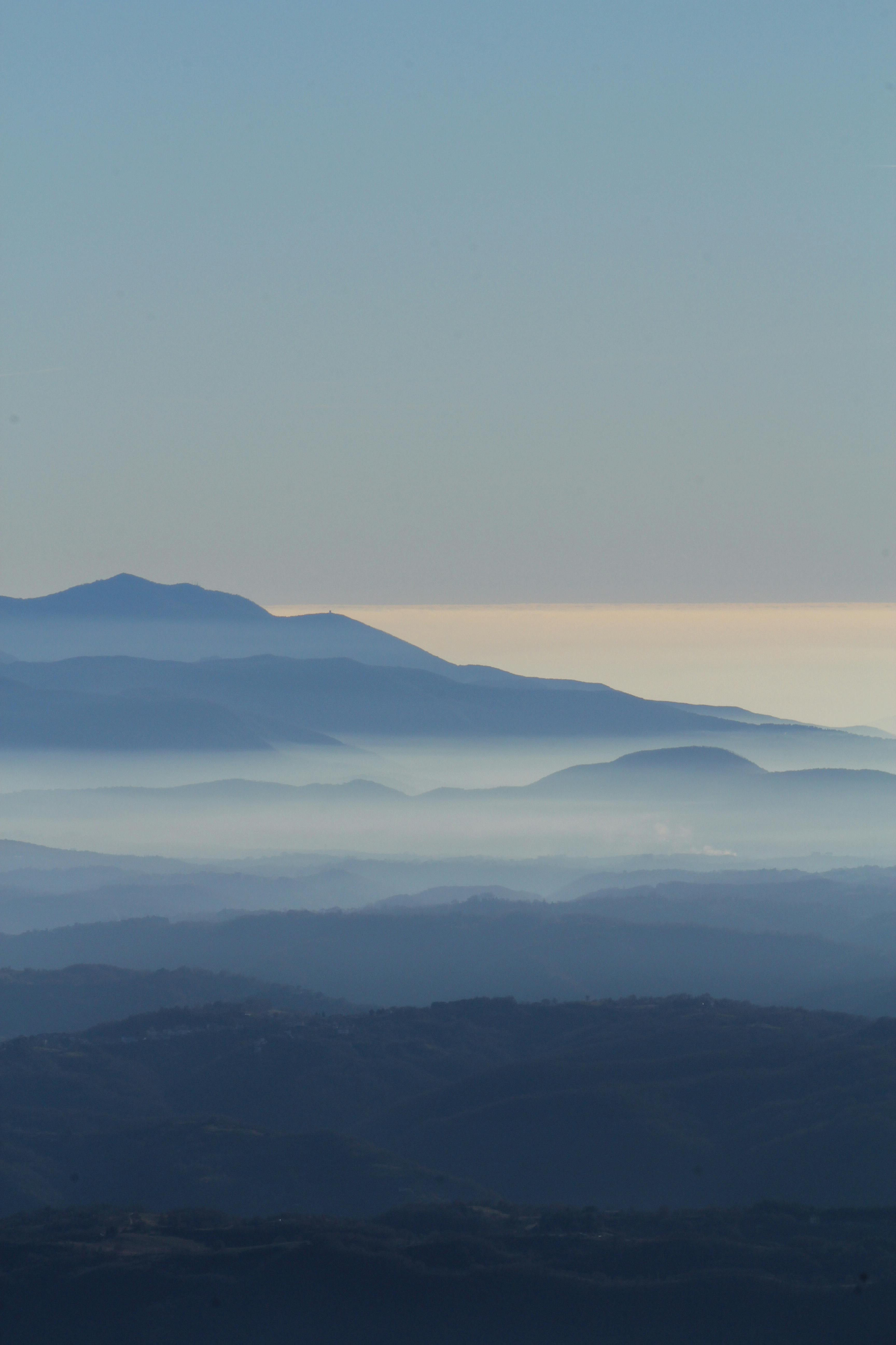 Peaceful mountain landscape with misty layers in soft morning light.
