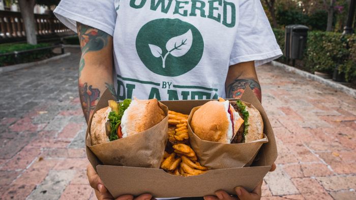 Someone carrying a tray of plant-based burgers — photo by Zuriel Escobedo on Pexels