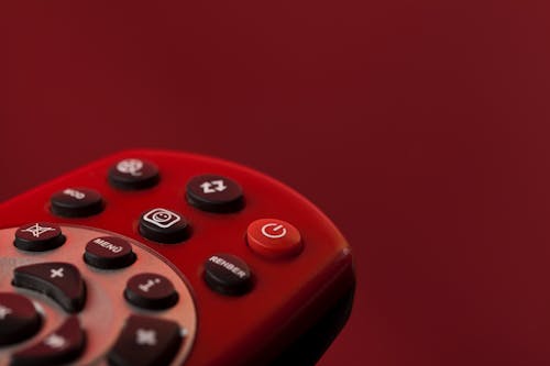 Free A Red Remote Control on Red Surface Stock Photo