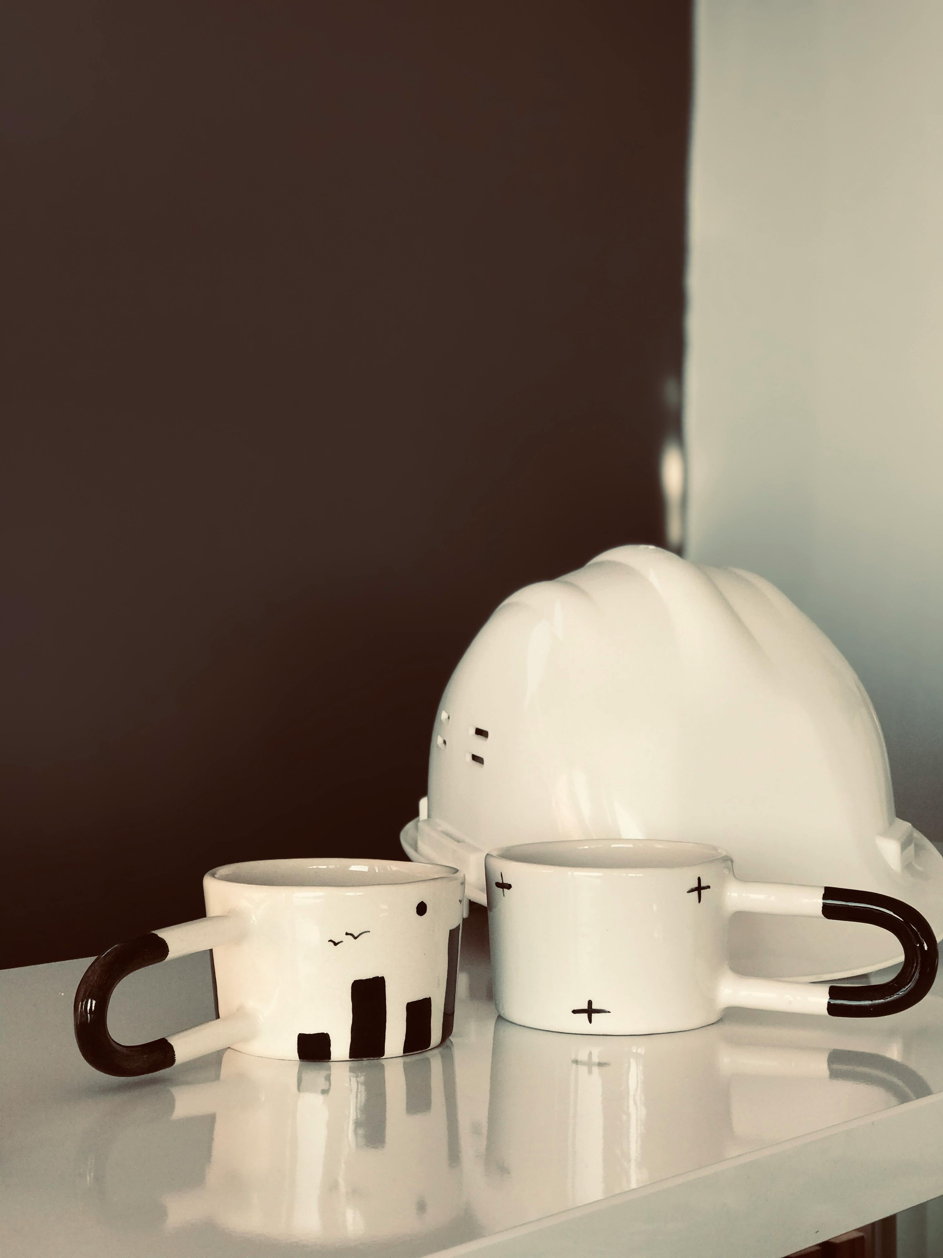 ceramic mugs beside the safety helmet