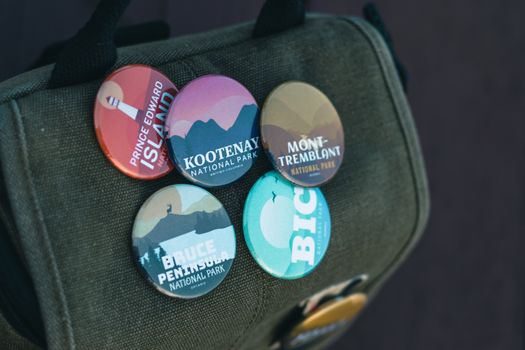 Close-up of national park souvenir badges on a backpack promoting travel and exploration.