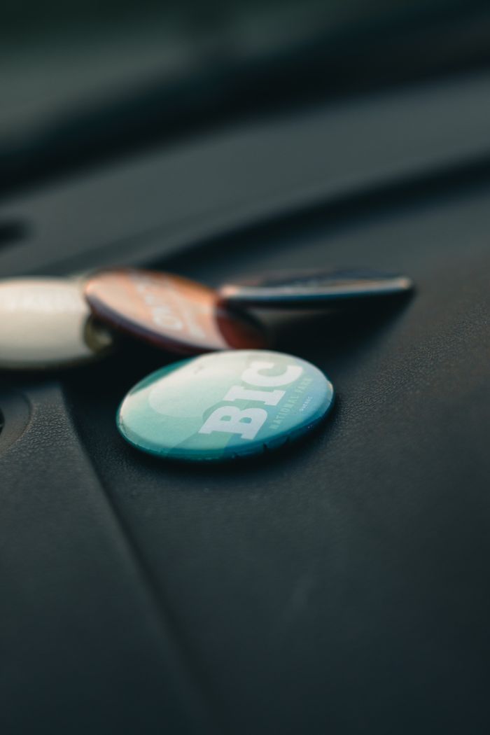 Assorted metal button pins on a dark textured surface