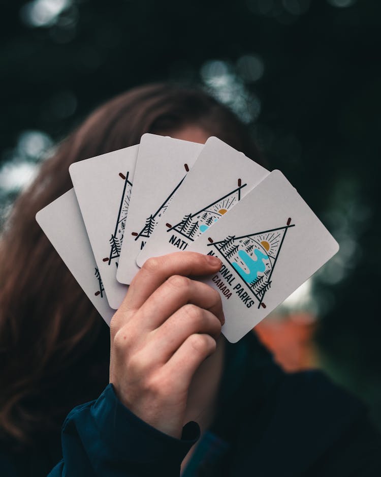 A Person Holding White Cards