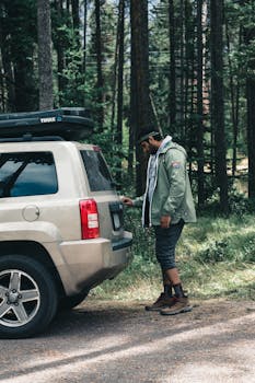 Man in green jacket preparing SUV for wilderness adventure in Canada.