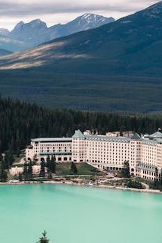 Aerial view of the Fairmont Chateau Lake Louise with turquoise water and mountains in Canada.