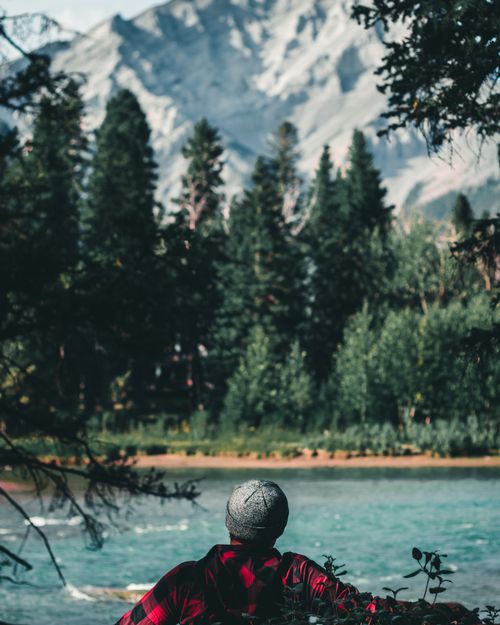 Free A person relaxing by a river with a majestic mountain backdrop in Canada. Stock Photo