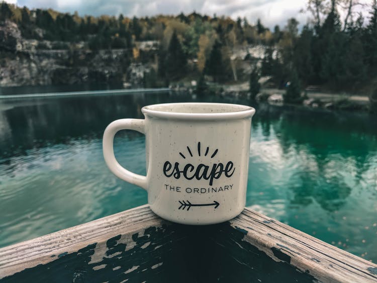 Ceramic Cup Sitting On Wooden Balcony Overlooking Lake