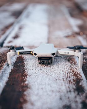 Compact drone sits on a frosty wooden surface, showcasing modern technology.