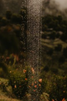 A mystical scene of fine mist droplets cascading in a lush, verdant landscape, creating a dreamy atmosphere.
