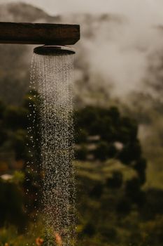 A serene outdoor shower resembling rainfall against a lush natural backdrop.