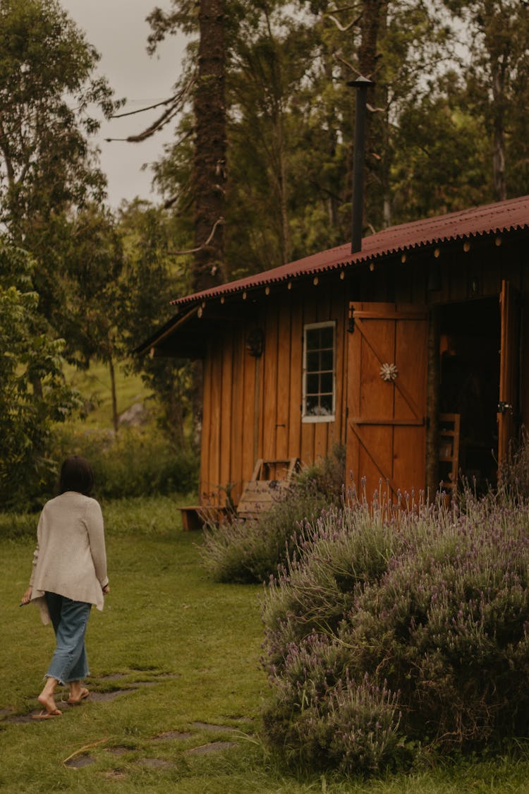 Woman Walking To Wooden House