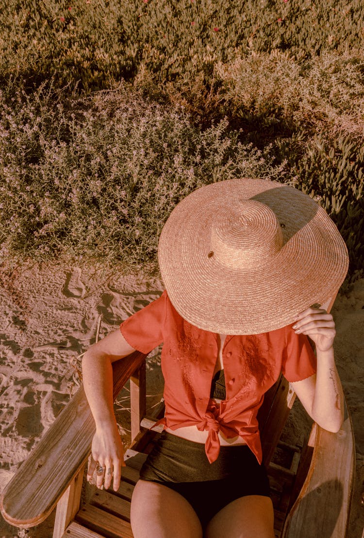 Woman In Hat Sitting In Sun Chair