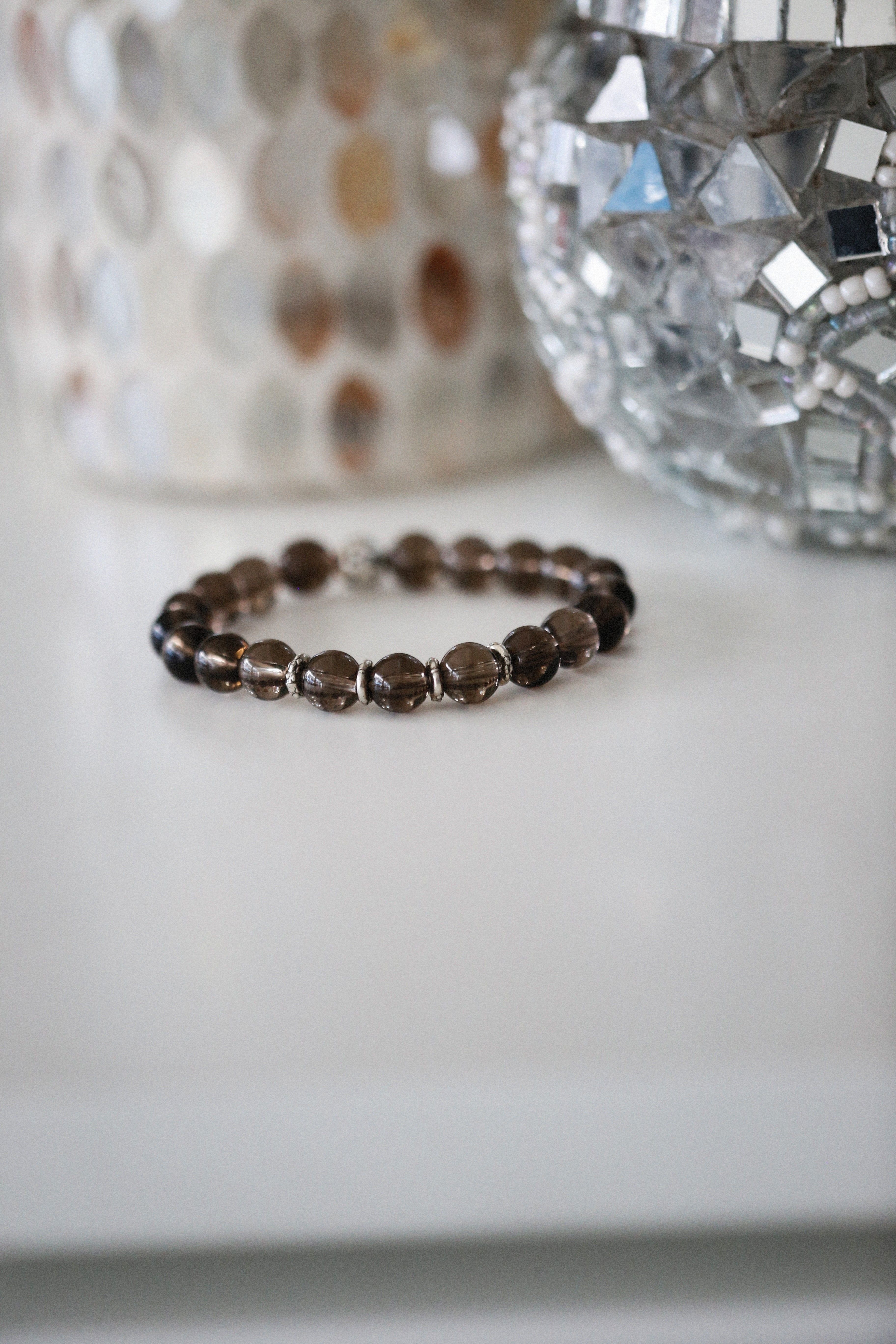 Bracelet de perles posé sur une surface claire.